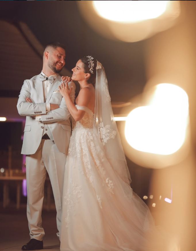 Bride and groom walking beside a reflecting pool at night
